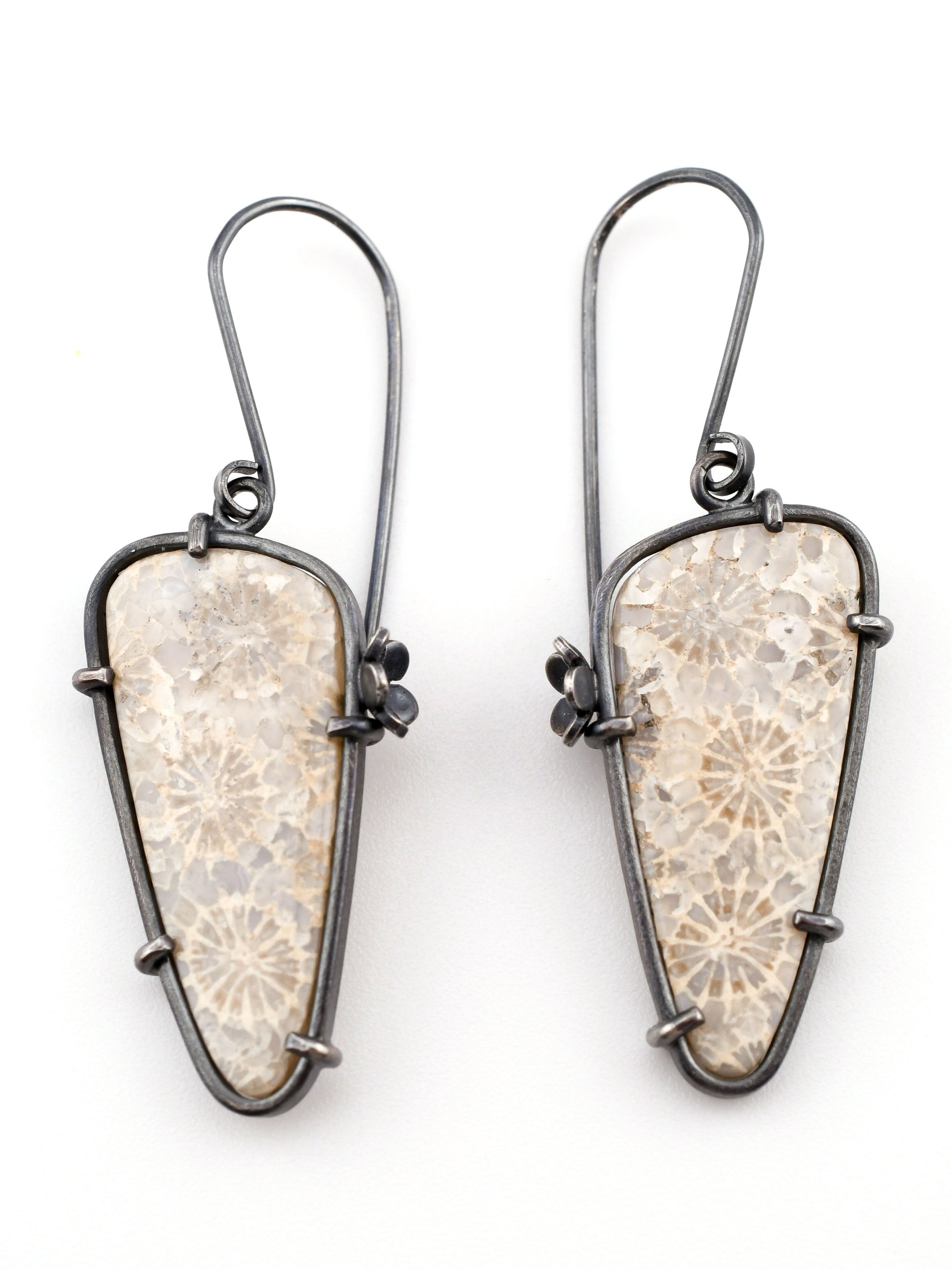 Pair of earrings with textured stone-like design on a white background