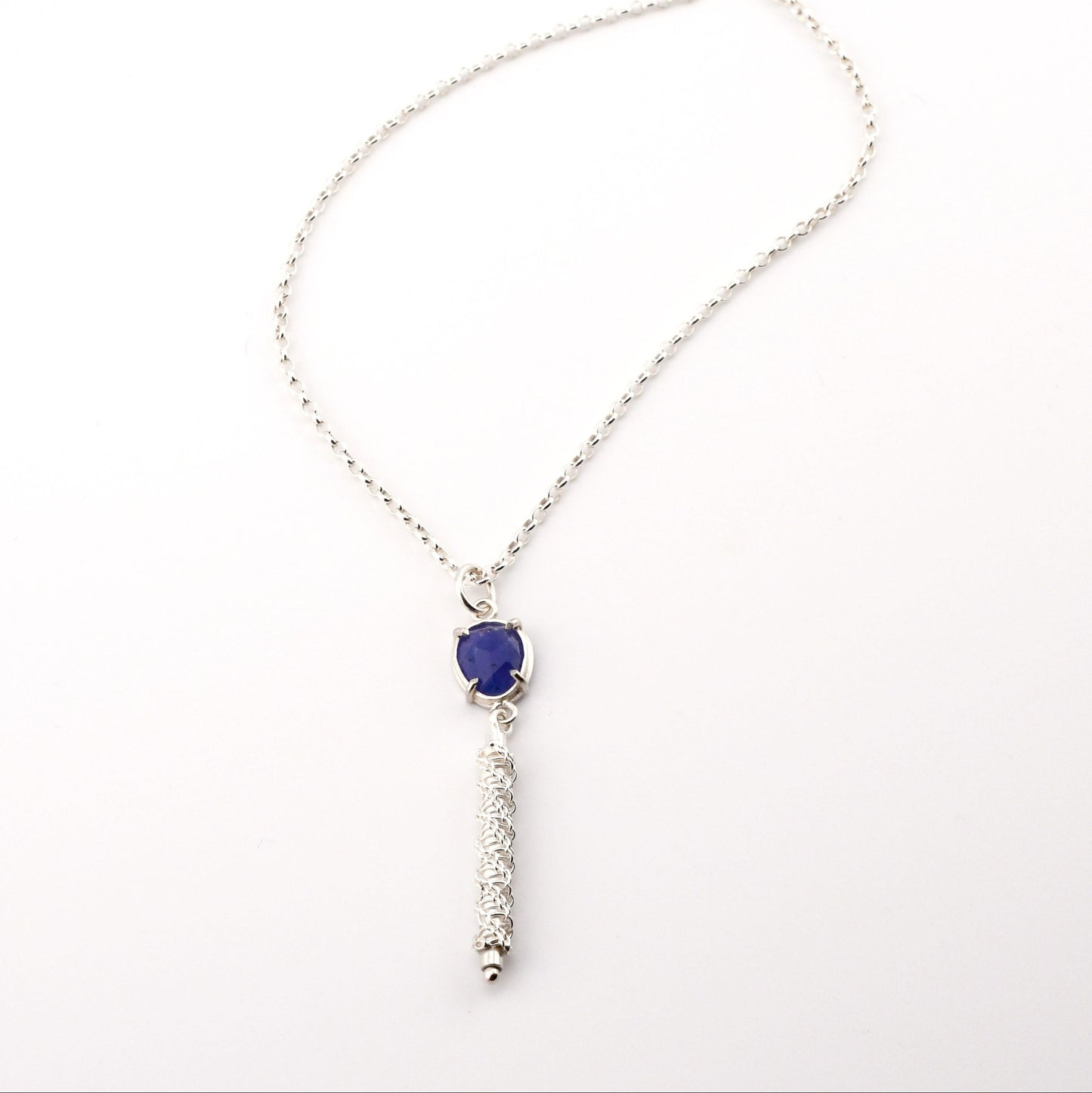 Silver necklace with a blue pendant on a white background