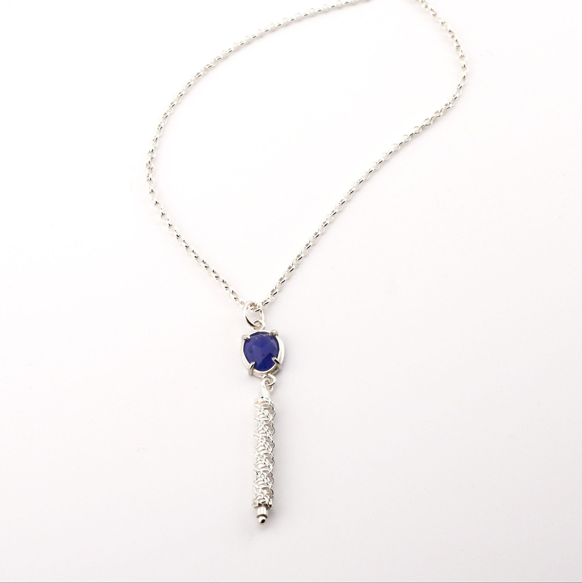 Silver necklace with a blue pendant on a white background