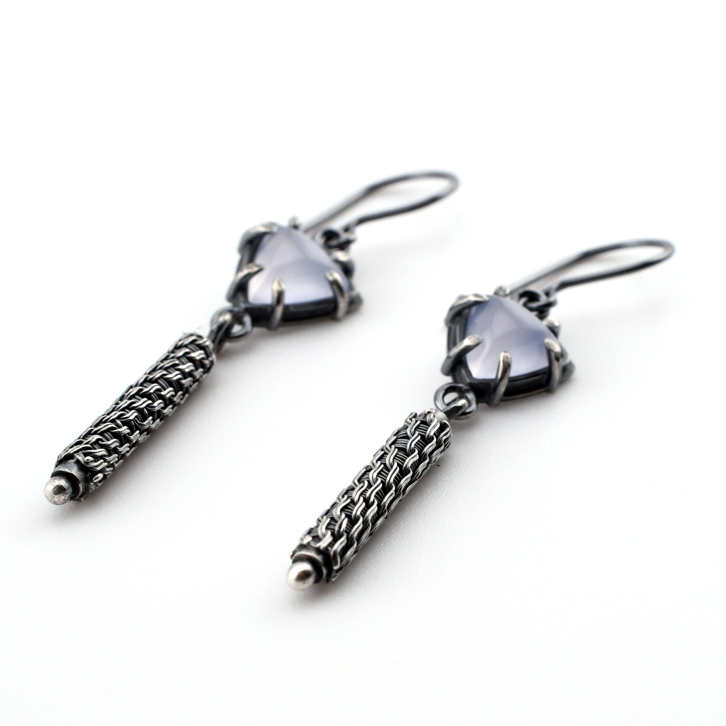 pale lavender stones with textured silver earrings on a white background