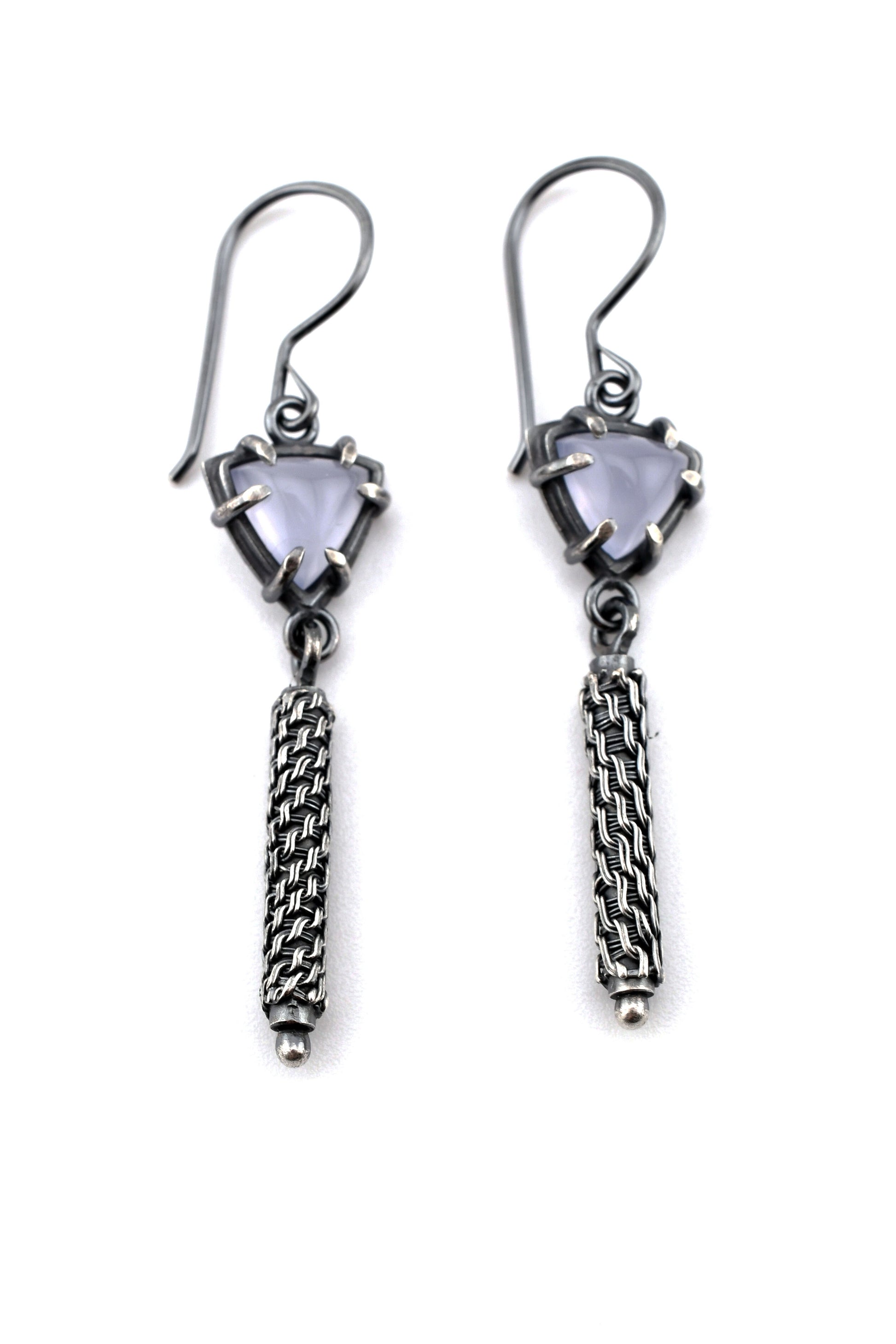 Pair of silver earrings with gemstones and woven details on a white background
