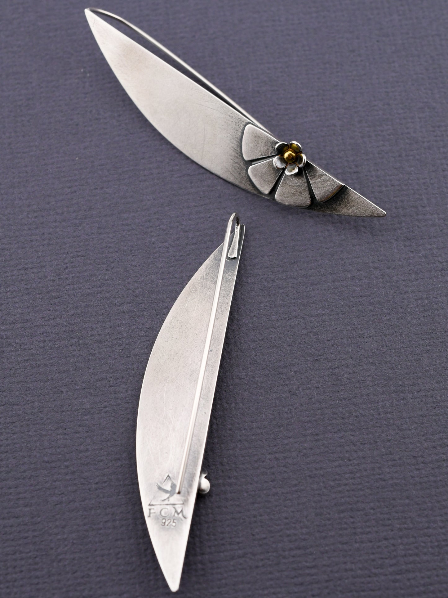 silver earrings on a textured gray background