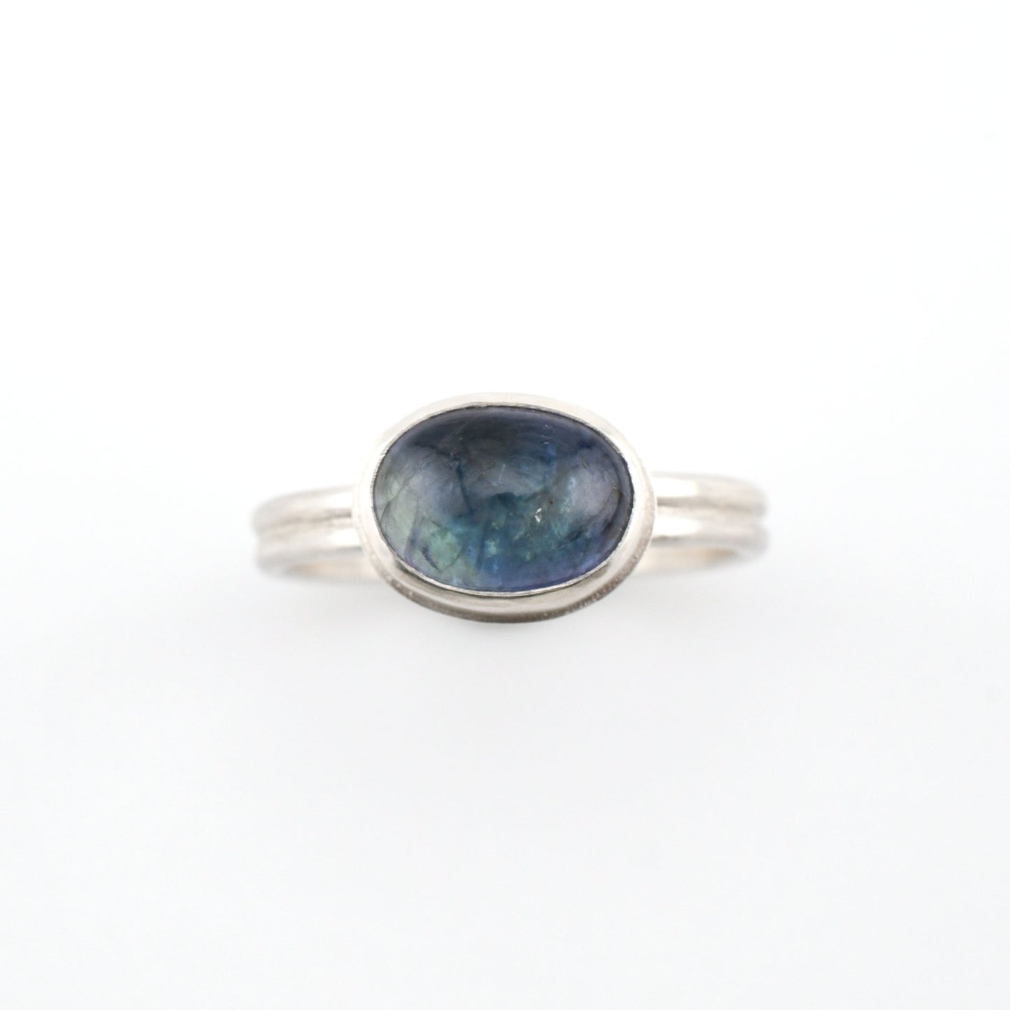 Silver ring with a blue gemstone on a white background