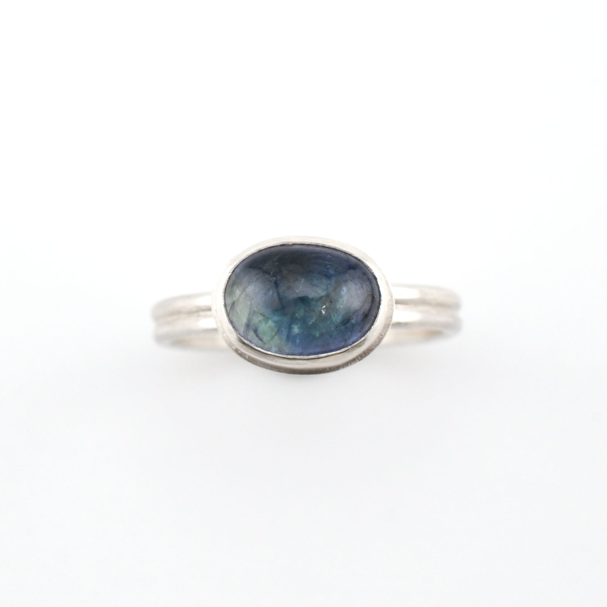 Silver ring with a blue gemstone on a white background