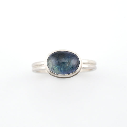 Silver ring with a blue gemstone on a white background