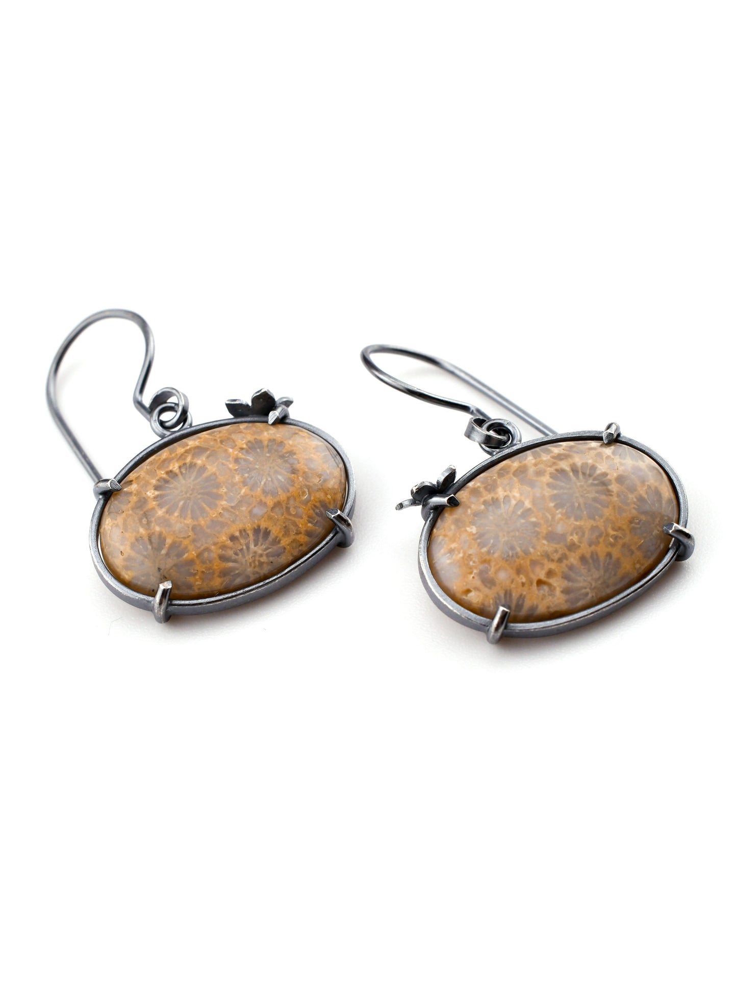oval fossil coral earrings with floral detail on a white background