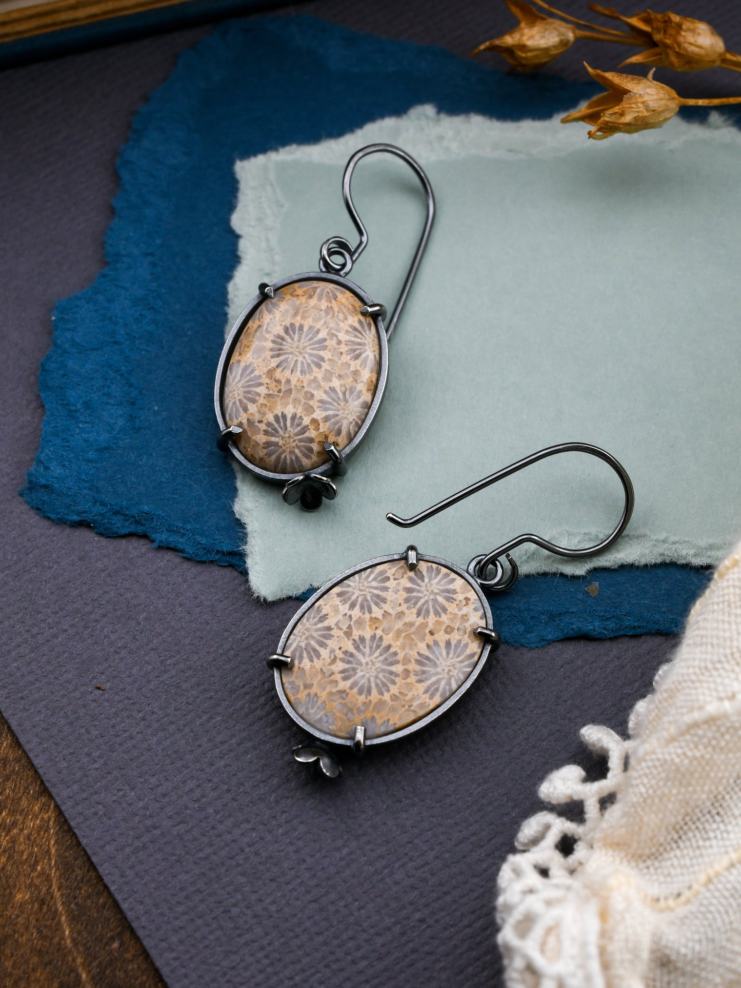 Pair of floral-patterned earrings on textured paper