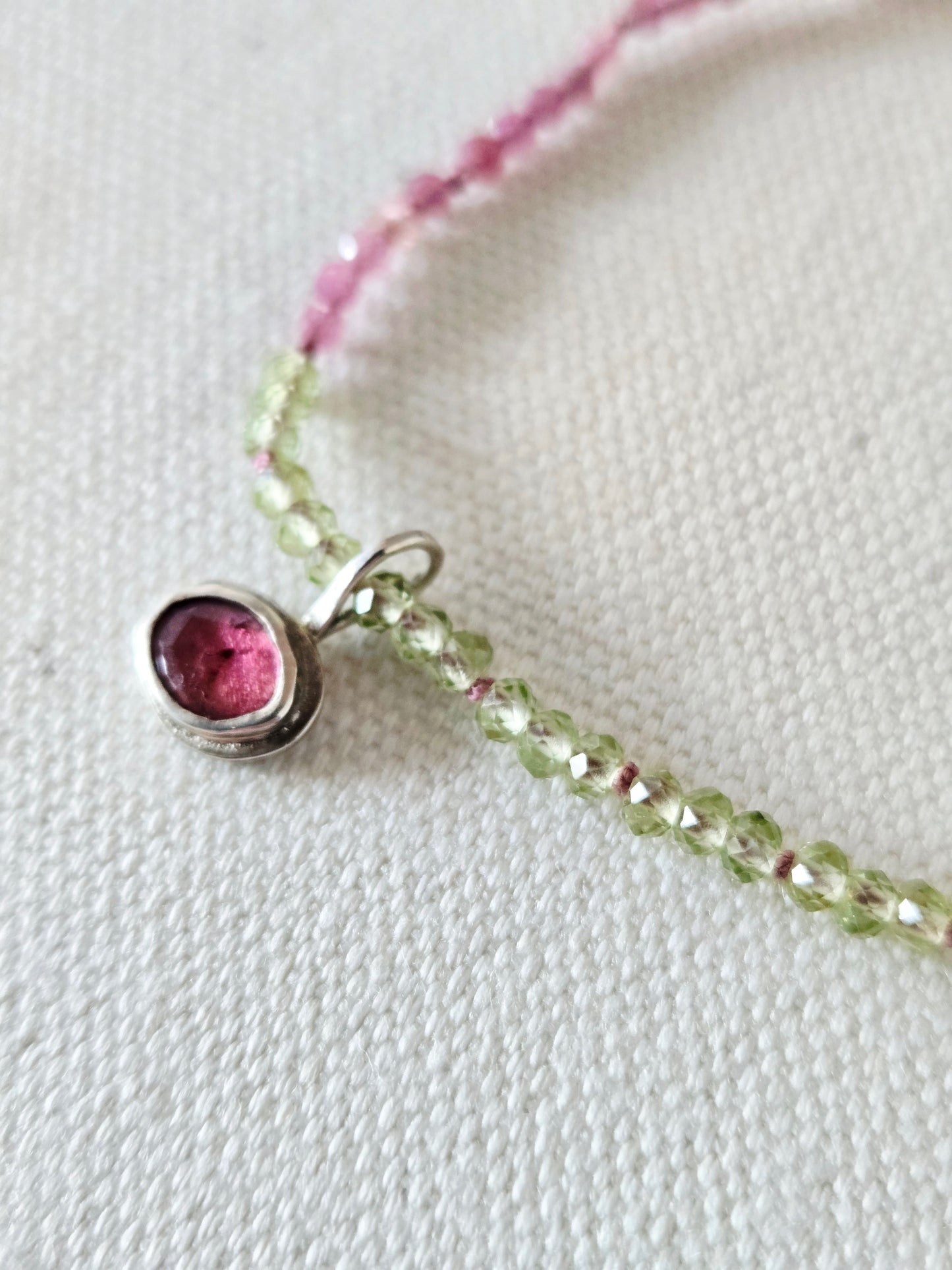 Necklace with a pink gemstone pendant on a white background