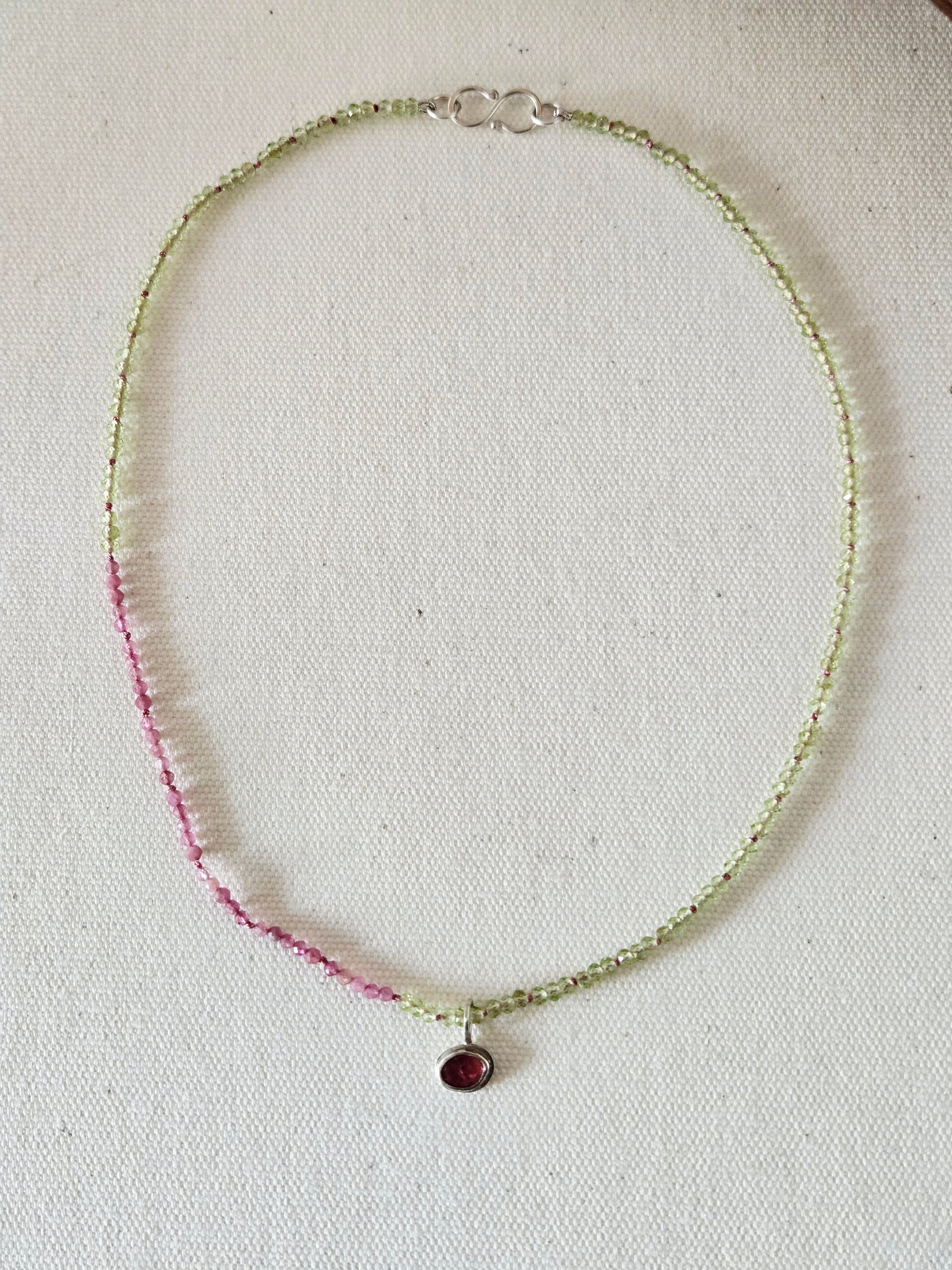 Necklace with a pendant on a light fabric background