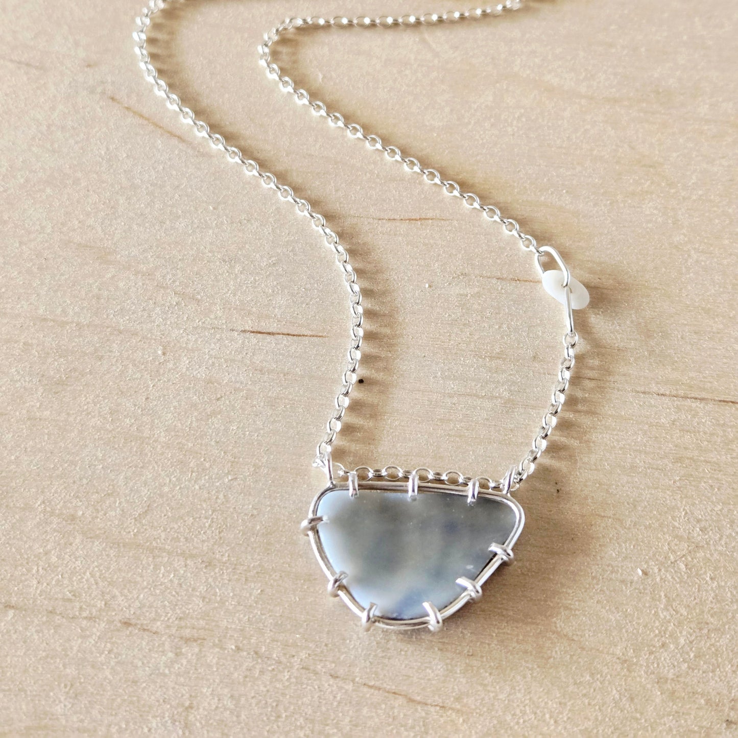 Necklace with a shell fragment pendant on a beige background