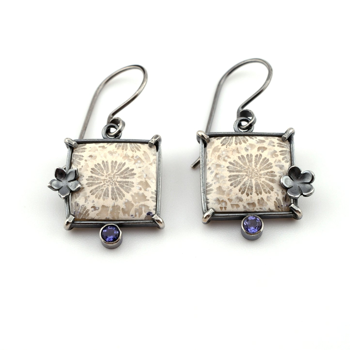 Square stone earrings with floral designs and violet gemstones on a white background