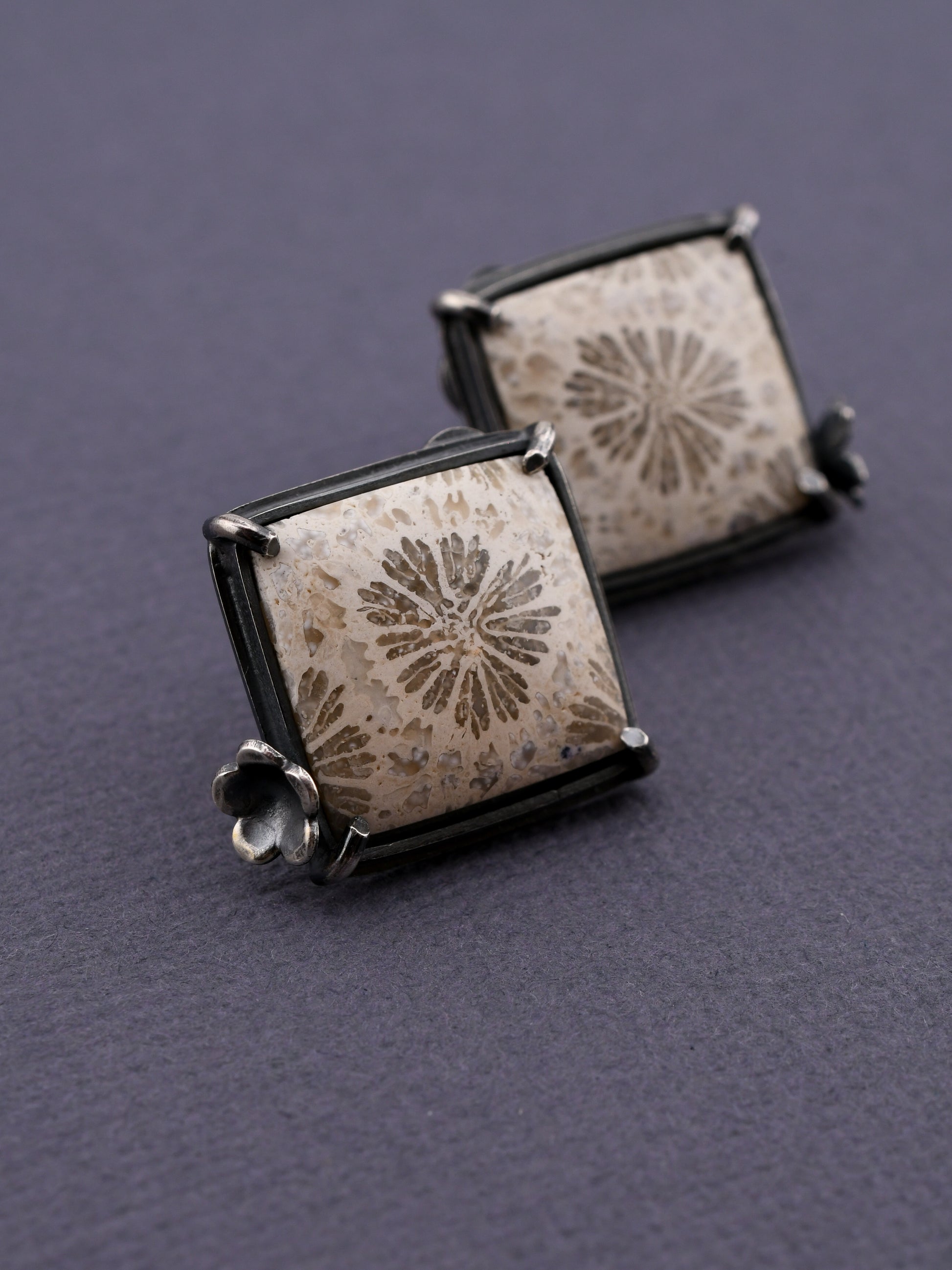 square white stone earrings with floral design on a dark gray background