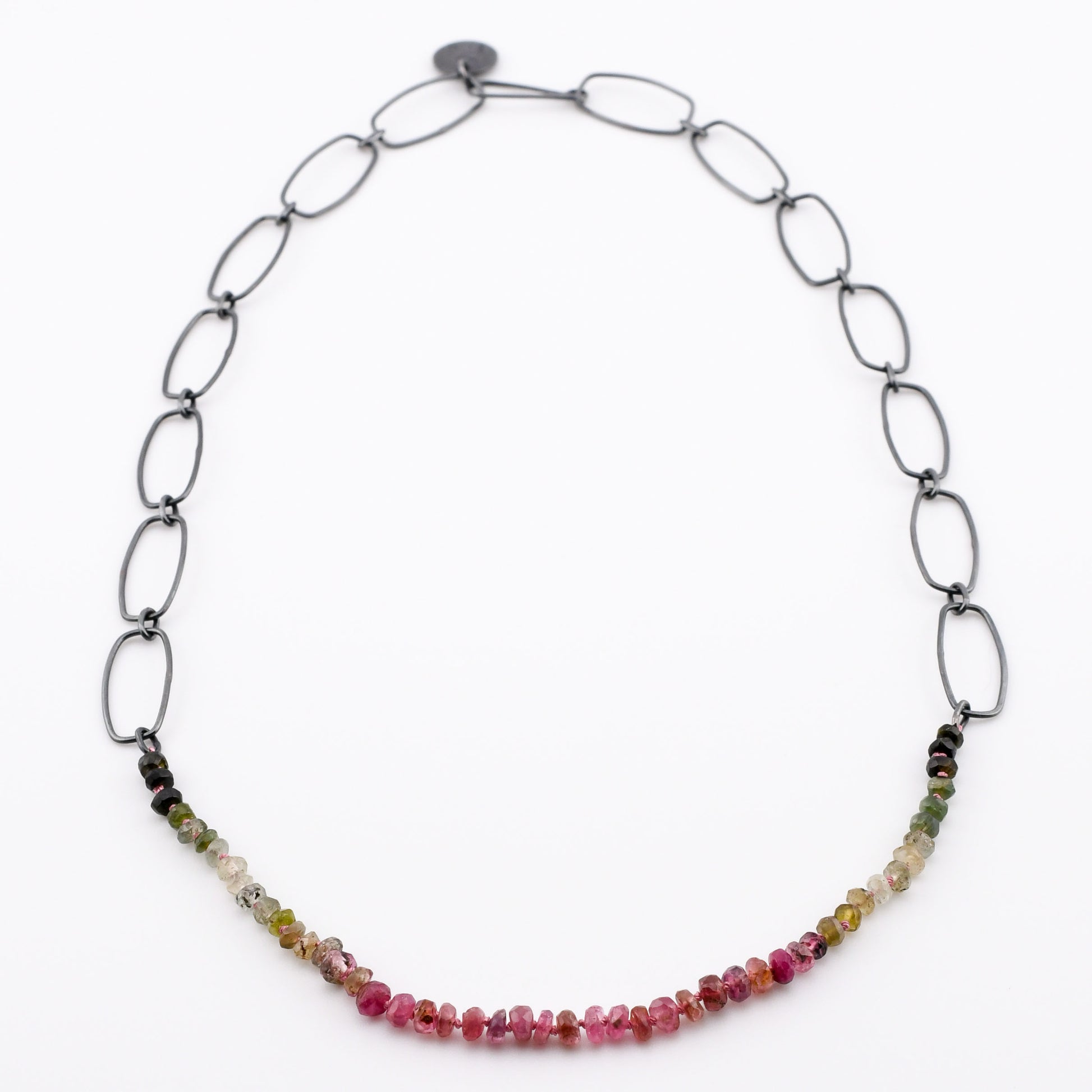 pink and green gradient beads with black silver chain on a white background
