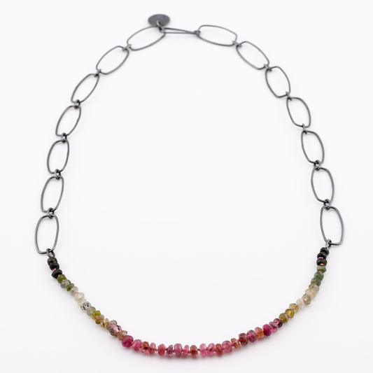 pink and green gradient beads with black silver chain on a white background