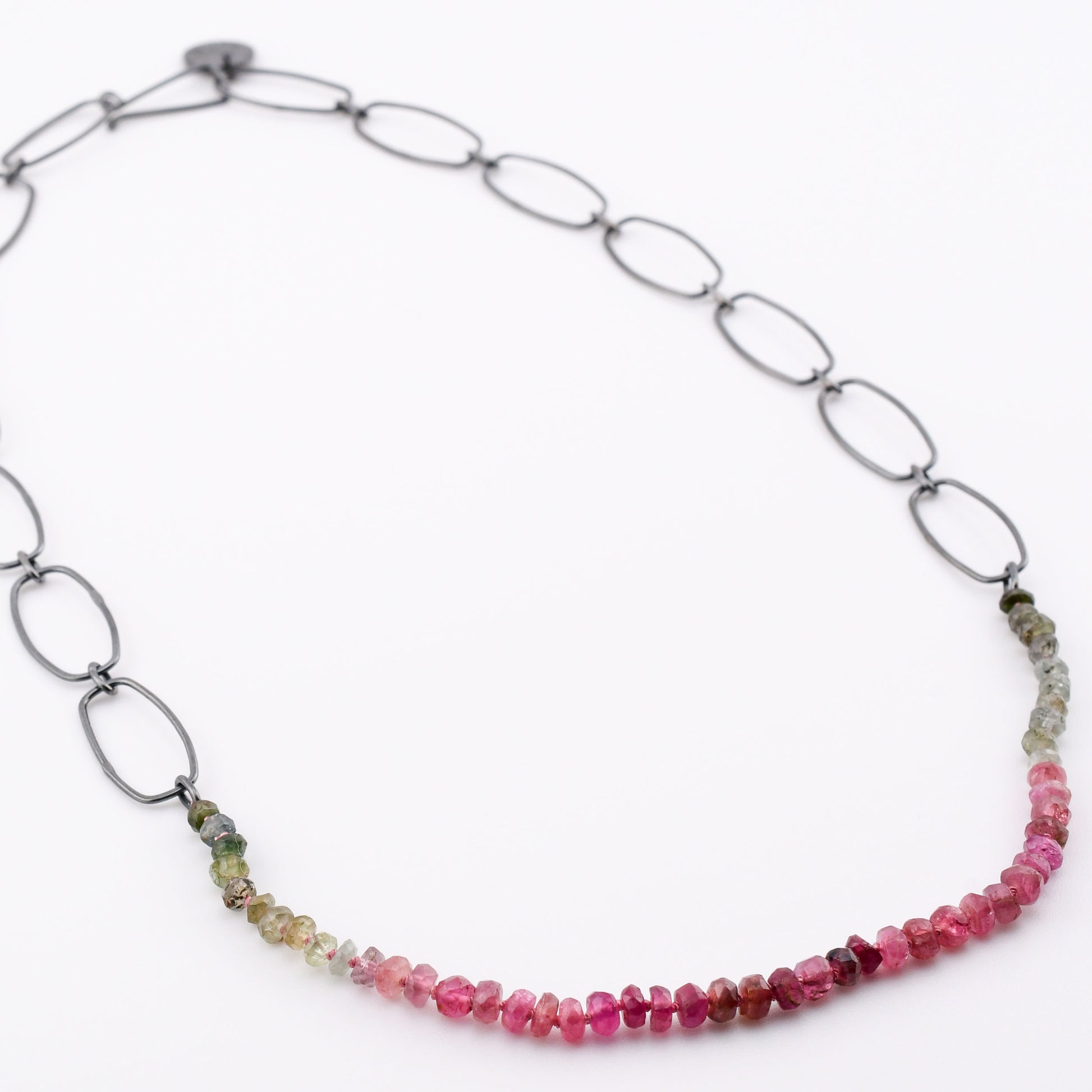 Necklace with pink and green bead chain on a white background