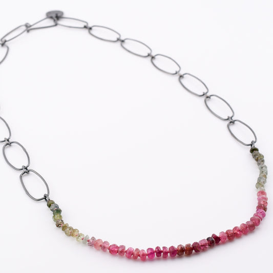 Necklace with pink and green bead chain on a white background