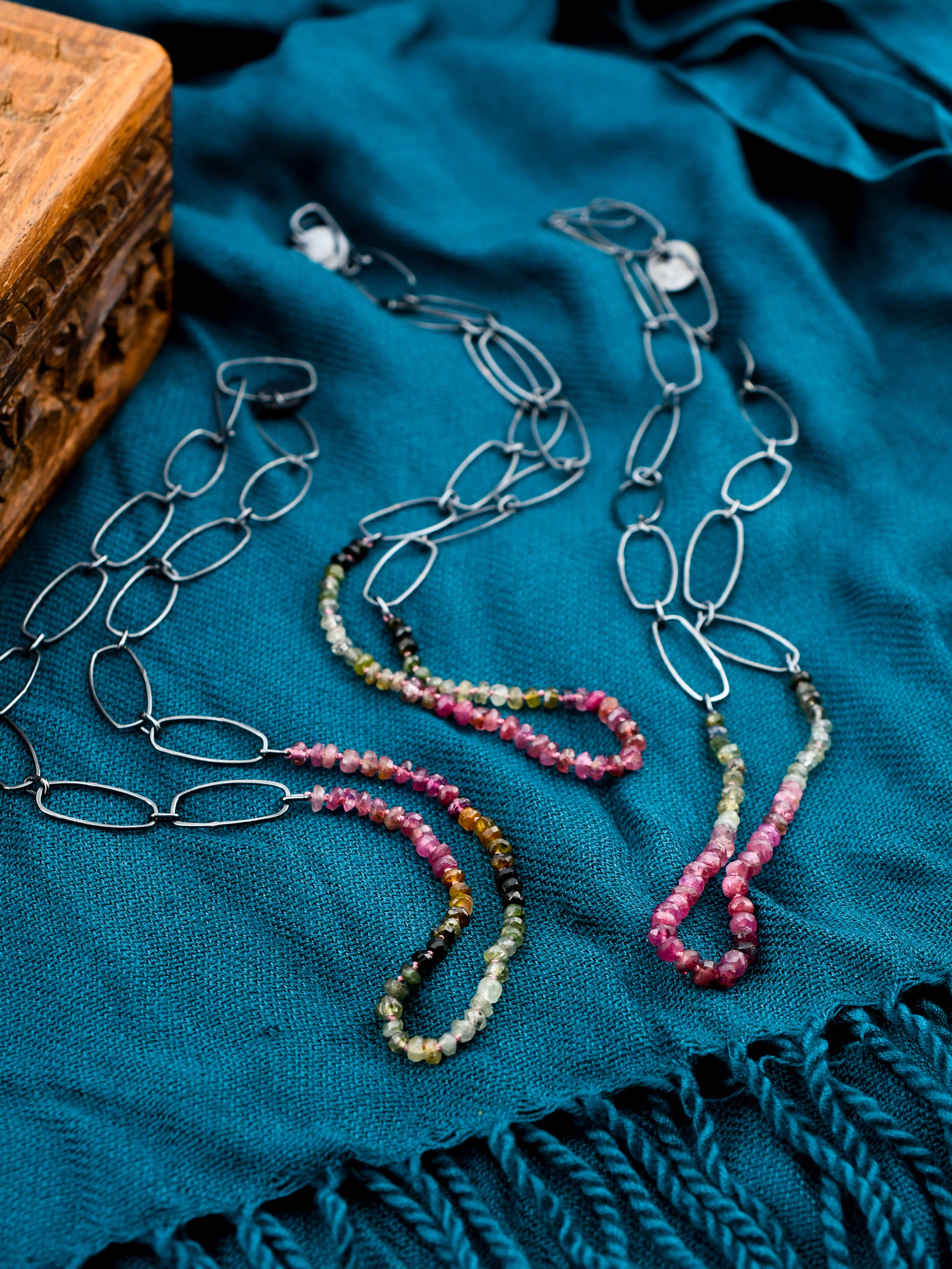 Jewelry set with beaded necklaces on a teal fabric background